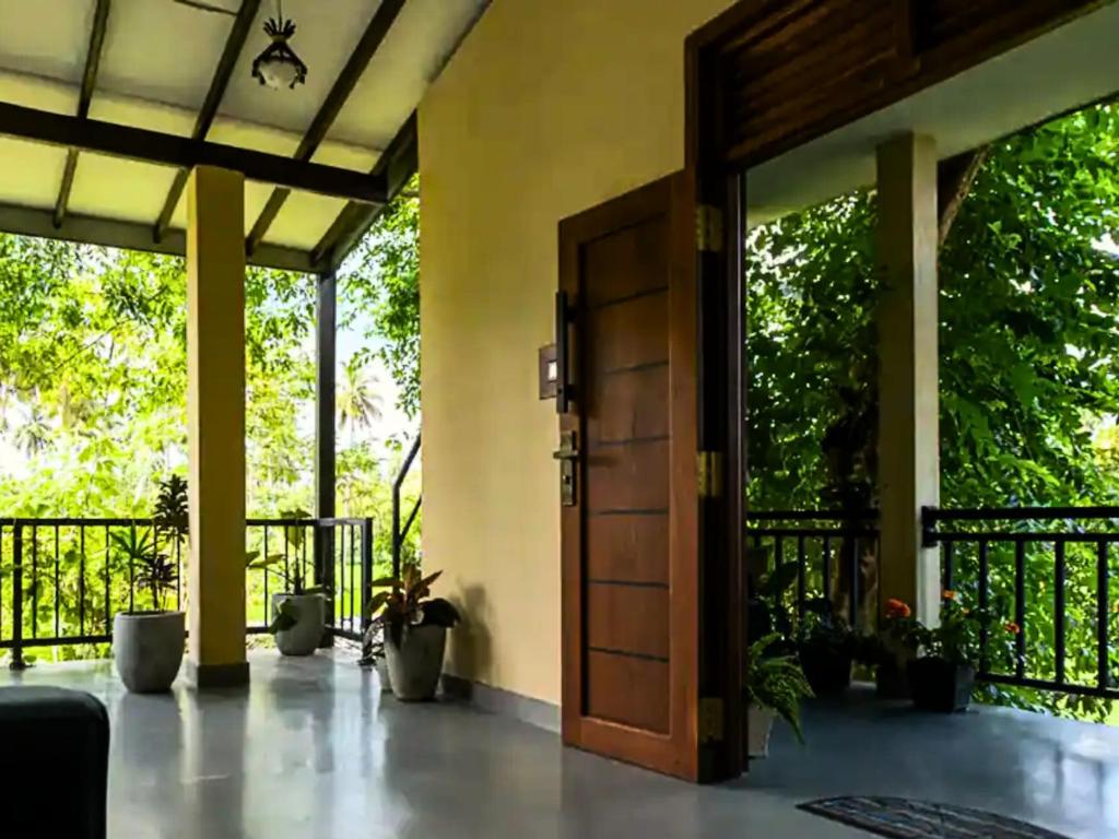 an open door to a patio with potted plants at Spacious 2 Bedroom Apartment with Lake View in Tangalle