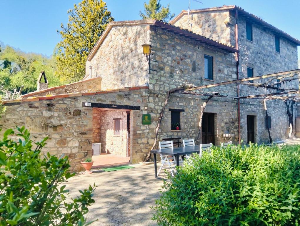 an old stone house with a table in front of it at Tudesia Charming house in Todi
