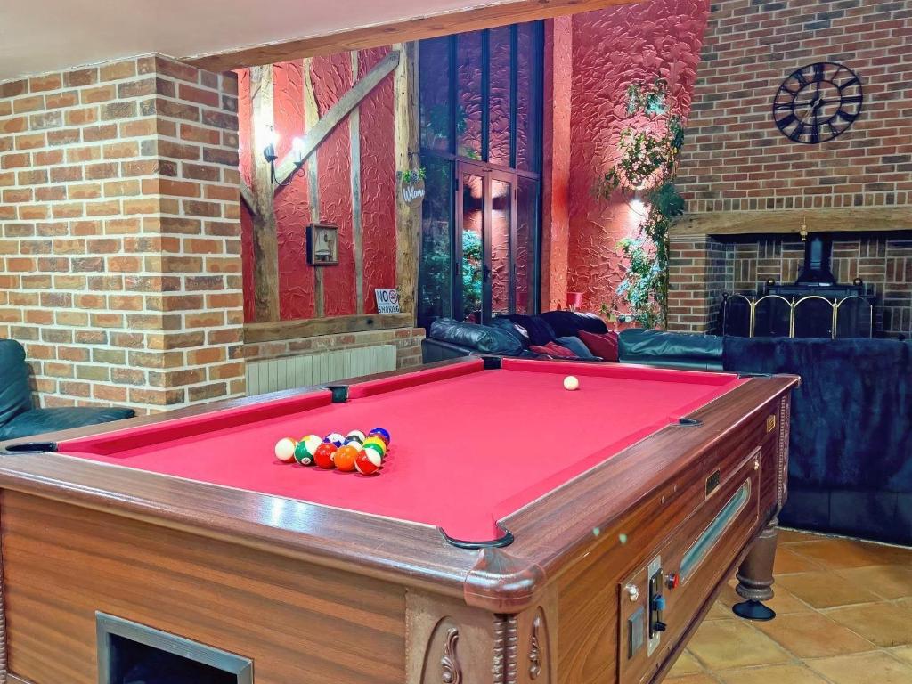 a red pool table with balls on top of it at Clamp Farm Barn in Stowmarket