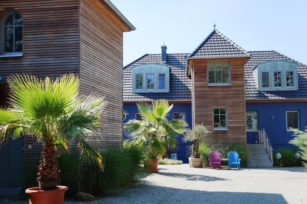 una casa con palmeras delante en BluGarden Ferienapartments im Spreewald, en Lübben