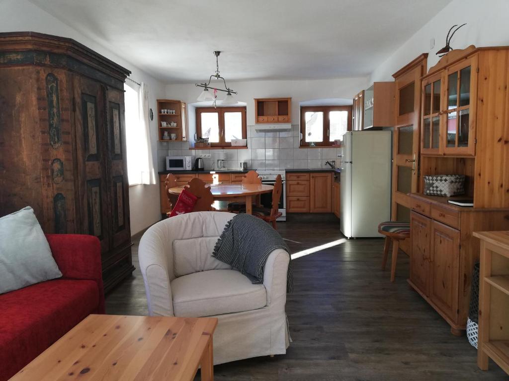 a living room with a white couch and a kitchen at Erlhofer Apartments in Tröpolach