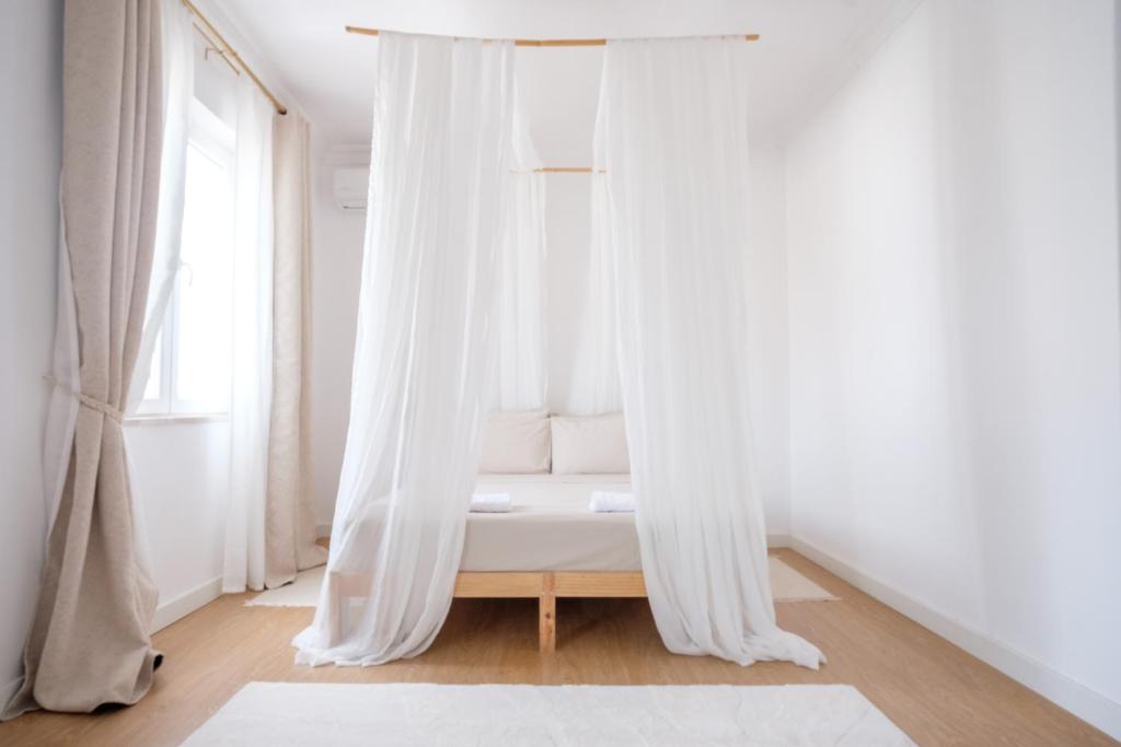 a white couch in a room with a window at Casa Rosa Sé - Luxury Boutique Guest House in Faro