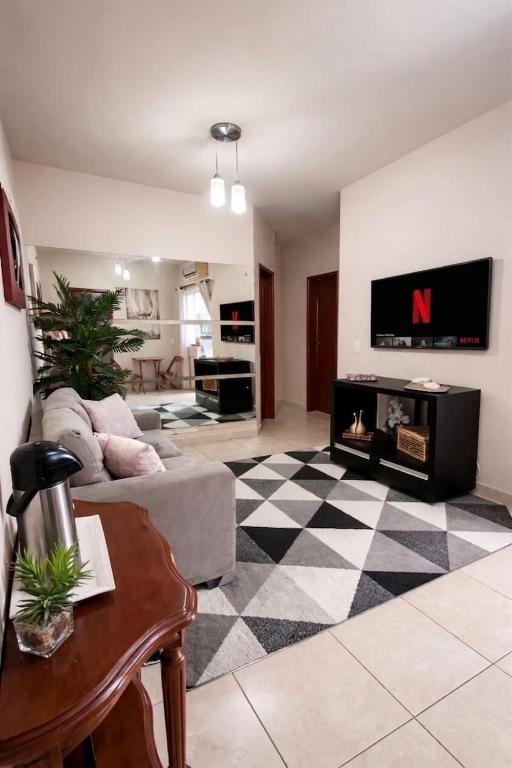 a living room with a couch and a tv at Apê estiloso e funcional no coração da cidade in Porto Velho