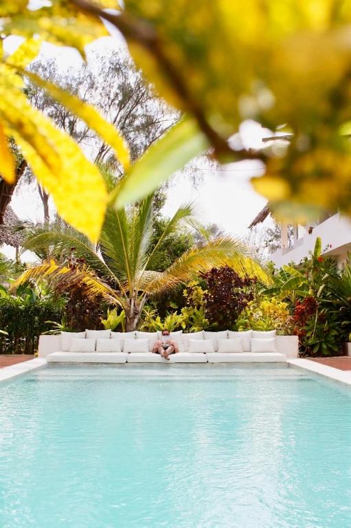 a person laying on the edge of a swimming pool at Kuwa Zanzibar in Kiwengwa