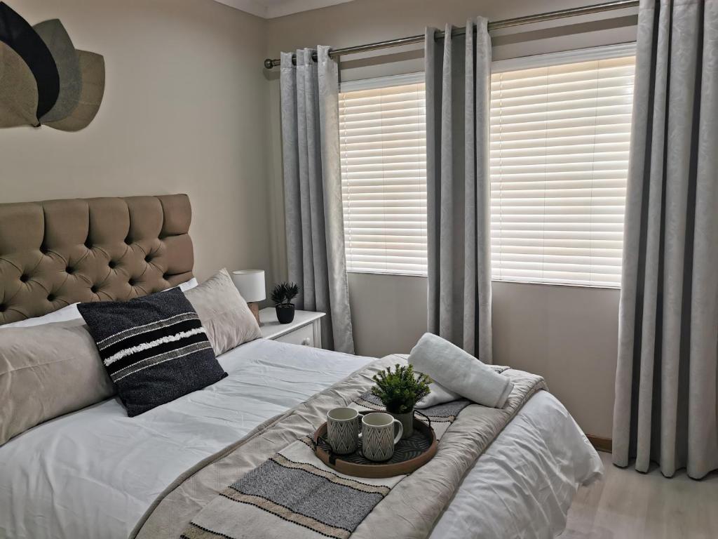 a bedroom with a bed with a tray on it at The Boho Suite in Benoni