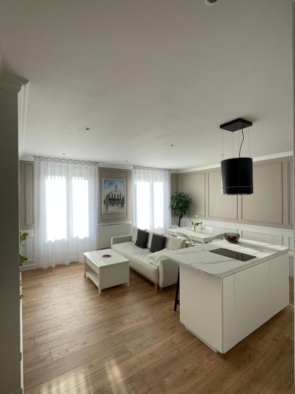 a white living room with a couch and a table at Belle escale by LV in Dieppe