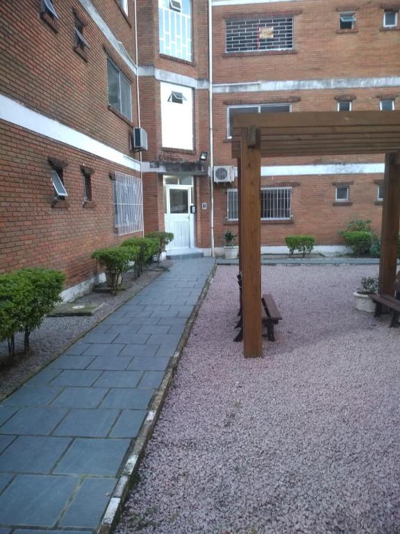 a courtyard of a building with benches in front of it at Apartamento em Pelotas Centro in Pelotas