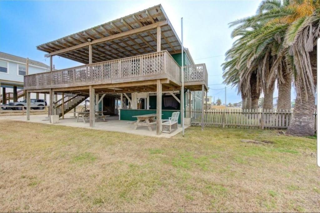 a house with a deck and palm trees at Palms Getaway in Freeport