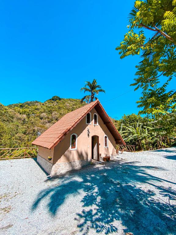 a small house with a palm tree on a hill at Chalé Espaço Raiz de Lumiar in Nova Friburgo