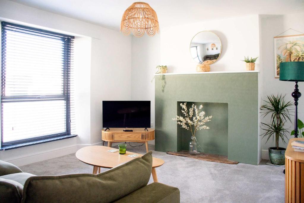 a living room with a couch and a tv at Rosa's Retreat - By Rowes Retreats in Falmouth