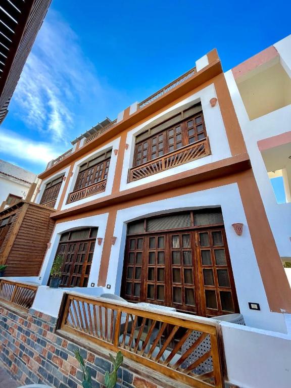 a house with wooden doors and a balcony at Santa Maria Dahab Hotel in Dahab
