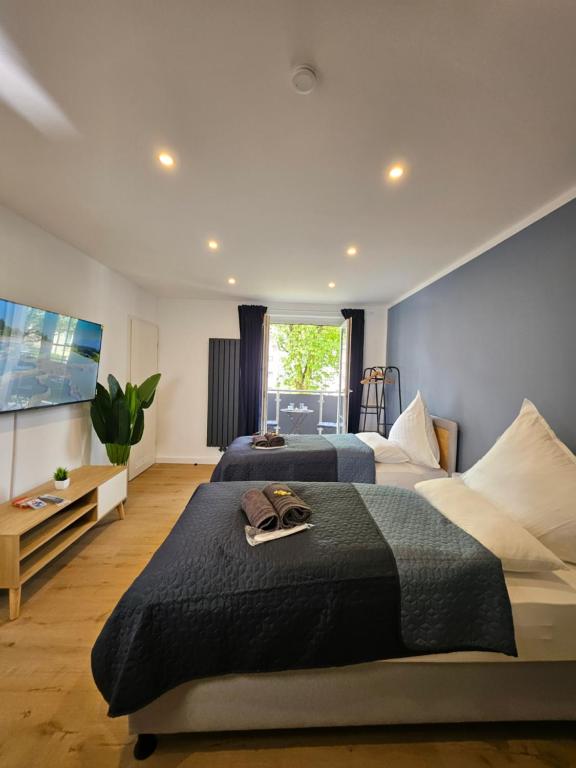 a bedroom with two beds and a flat screen tv at Stilvolle Wohnung mit Balkon & Parkplatz in Moers - Ideal für Business, Familien und Monteure nahe Düsseldorf in Moers