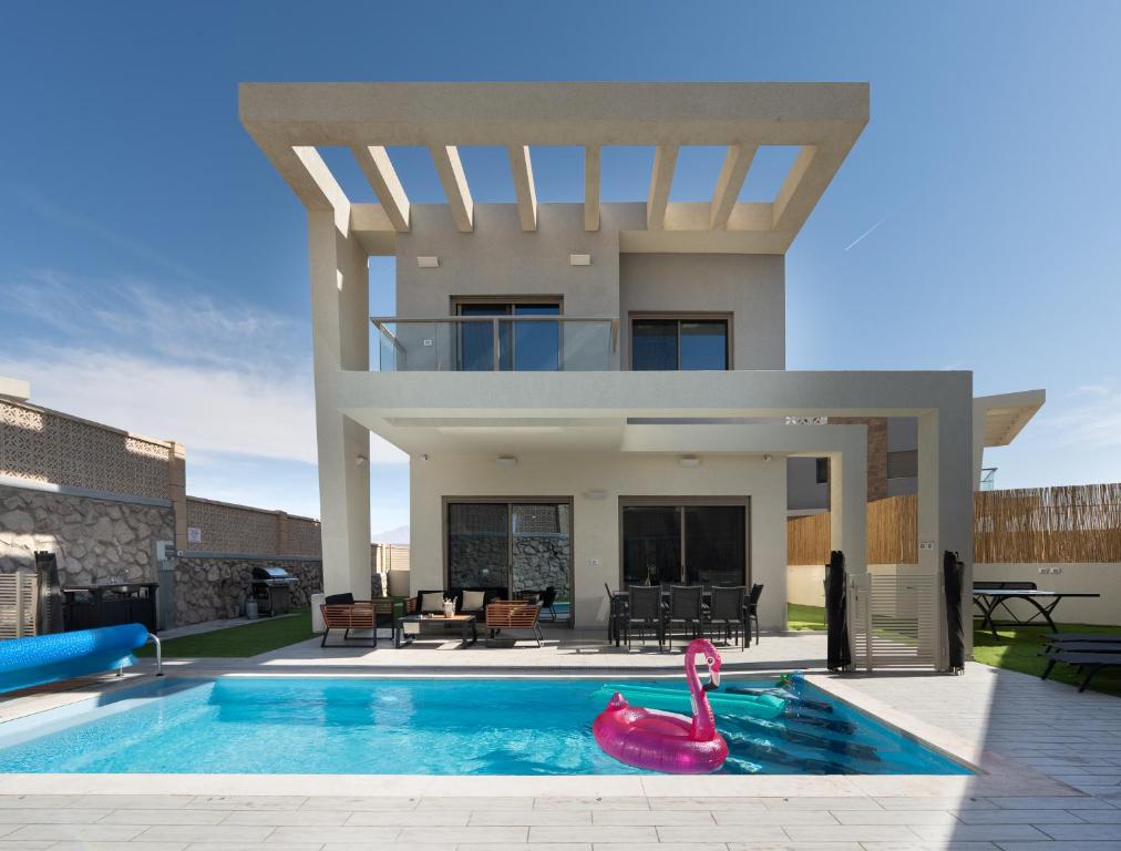 a house with a swimming pool in front of a house at וילה אקווה ויסטה DreamyRent Villa Aqua Vista in Eilat
