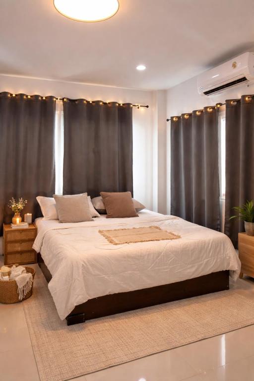 a bedroom with a large white bed with curtains at blissful well treat in Ban Madua Wan