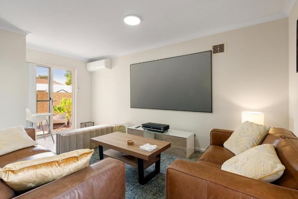 a living room with two couches and a flat screen tv at Elysian Fields in Joondalup in Perth
