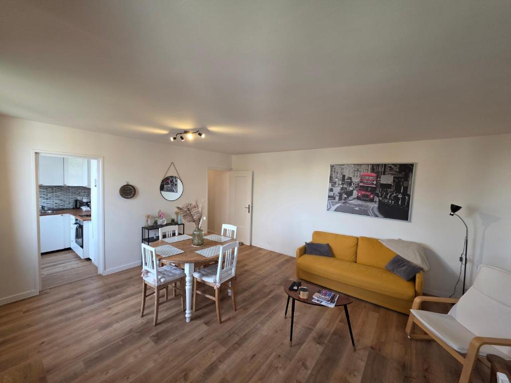 a living room with a yellow couch and a table at Chez Marie et Ludovic in Ronchin