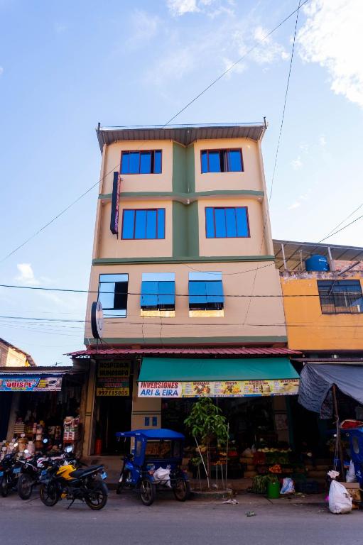 a tall building with blue windows on a street at Hospedaje Humazapa in Tarapoto