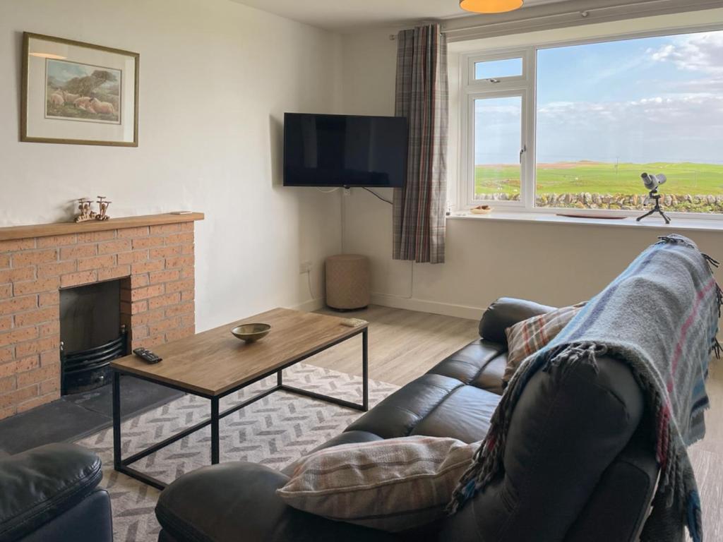 a living room with a couch and a fireplace at Machermore Cottage in Gillespie