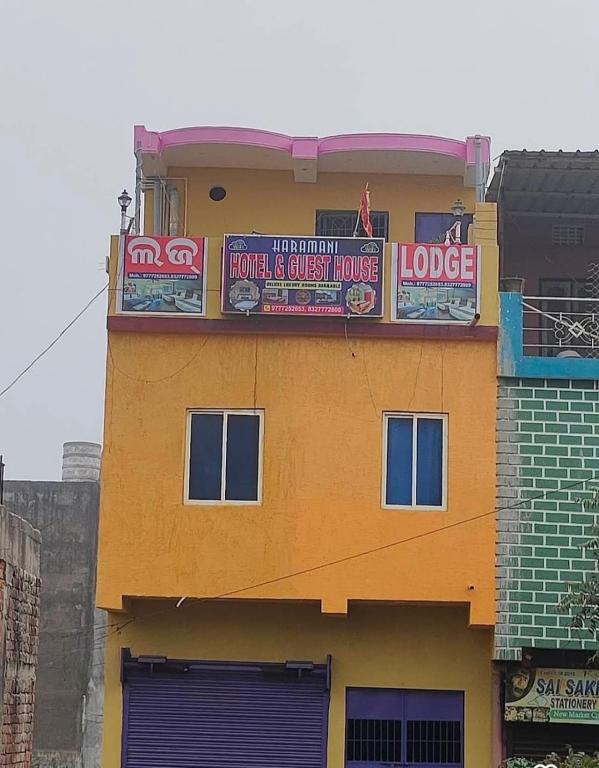 a yellow building with a sign on top of it at Haramani Guest House in Konārka