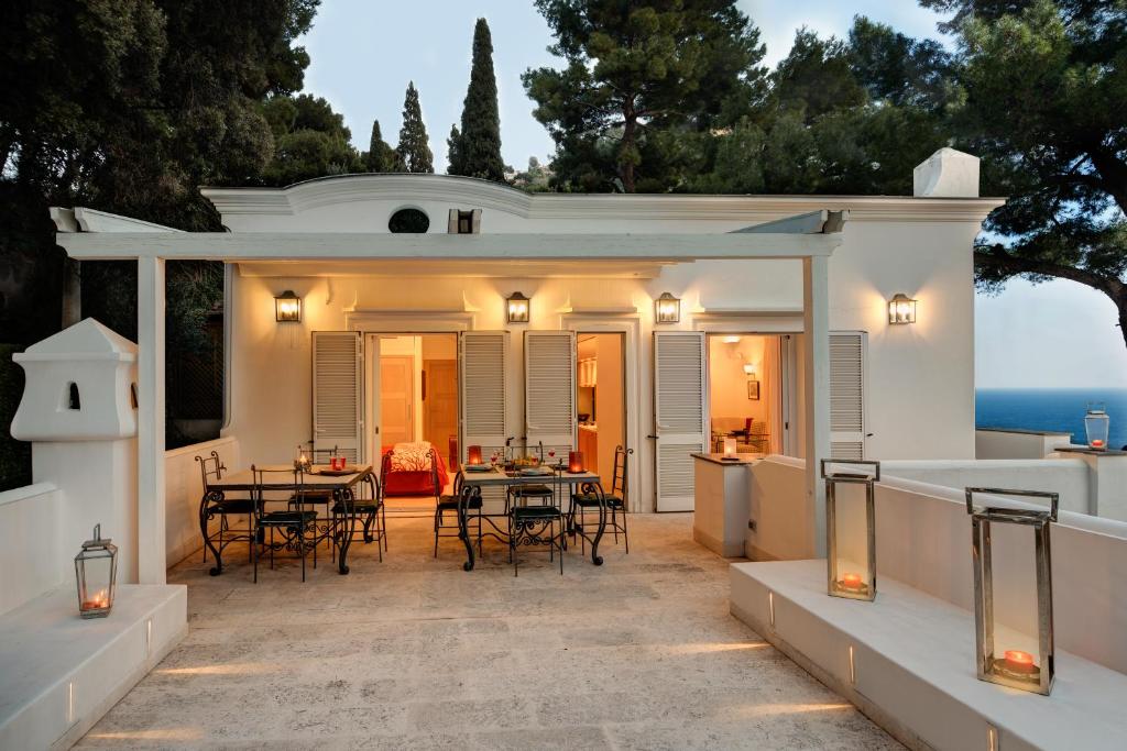a patio with tables and chairs in a house at GOCCE VILLAS - Villa Bouganvillea Superb Capri Villa with Views in Capri