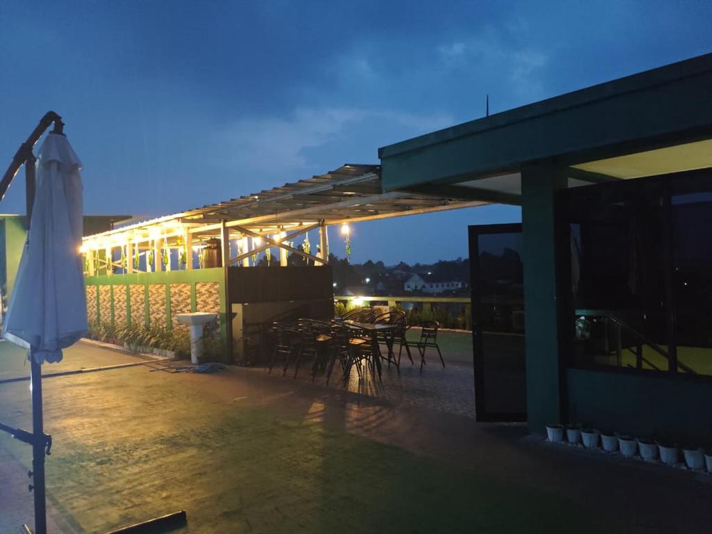 a lit up patio with tables and chairs at night at green hotel 2 ciamis in Ciamis