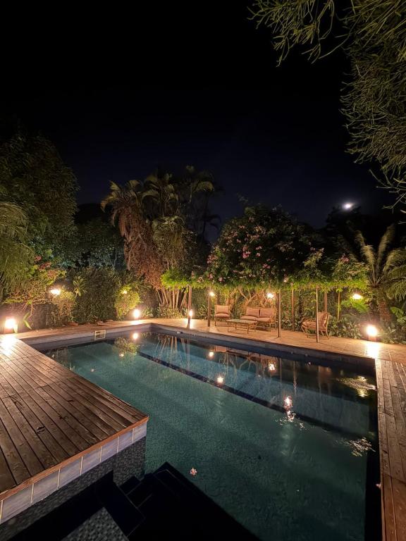 a swimming pool at night with a wooden deck at Casa de Campo Las Marías in Areguá