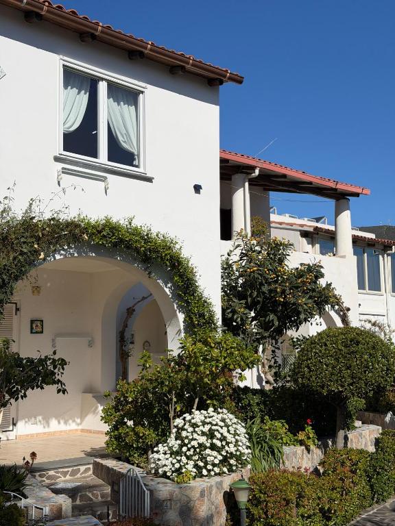 a white house with an archway and flowers at Hotel Residence Mendolita in Lipari