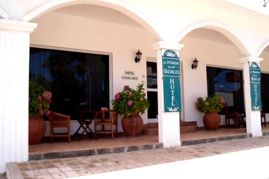 a building with two arches with potted plants on a patio at La Posada de los Robles in Las Grutas