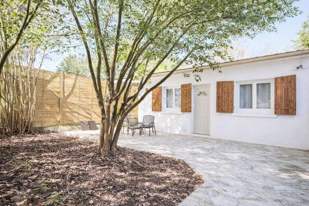 a tree in a yard next to a house at 5 Mins to Train Station - Paris & DisneyLand - Cosy des Reves Villiers in Villiers-sur-Marne