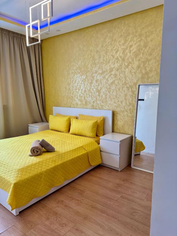 a bedroom with a yellow bed and a mirror at Studio pas cher au parc in Mohammedia