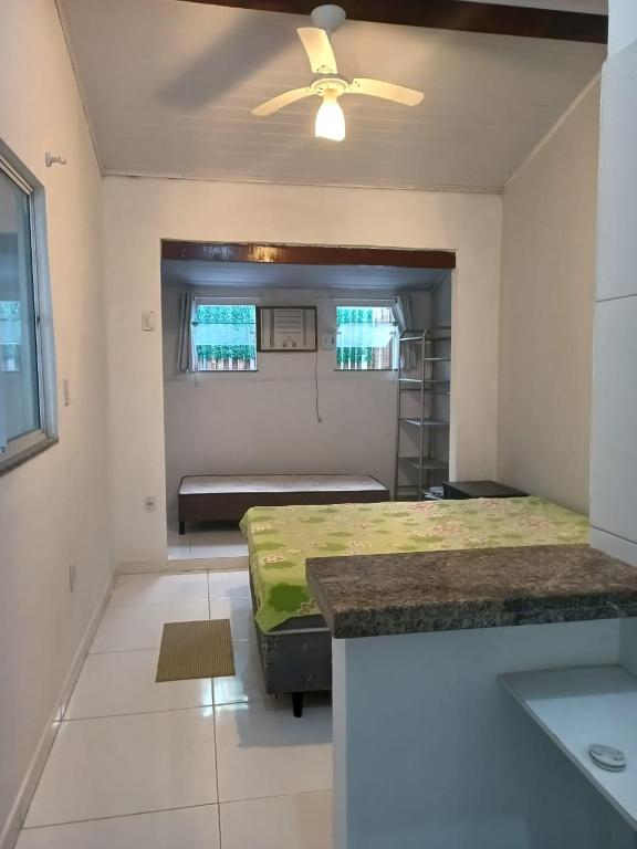 a bedroom with a bed and a ceiling fan at Casa inteira 4 pessoas, 2 quartos, suite ar, 2 banheiros, home office, estacionamento, próx praia Itaúna in Saquarema