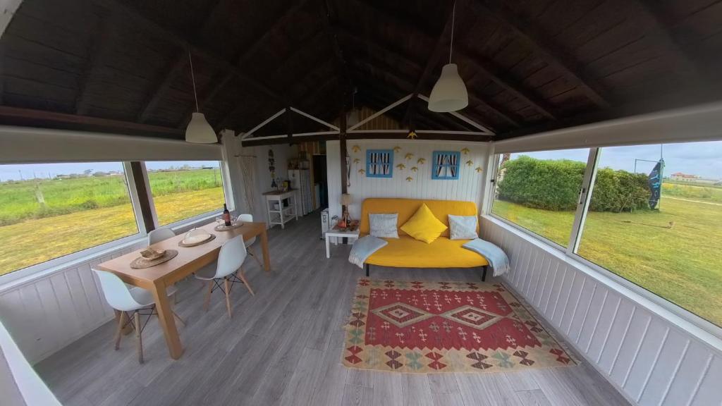 a bedroom with a yellow bed and a table and chairs at Casa dos Flamingos in Murtosa