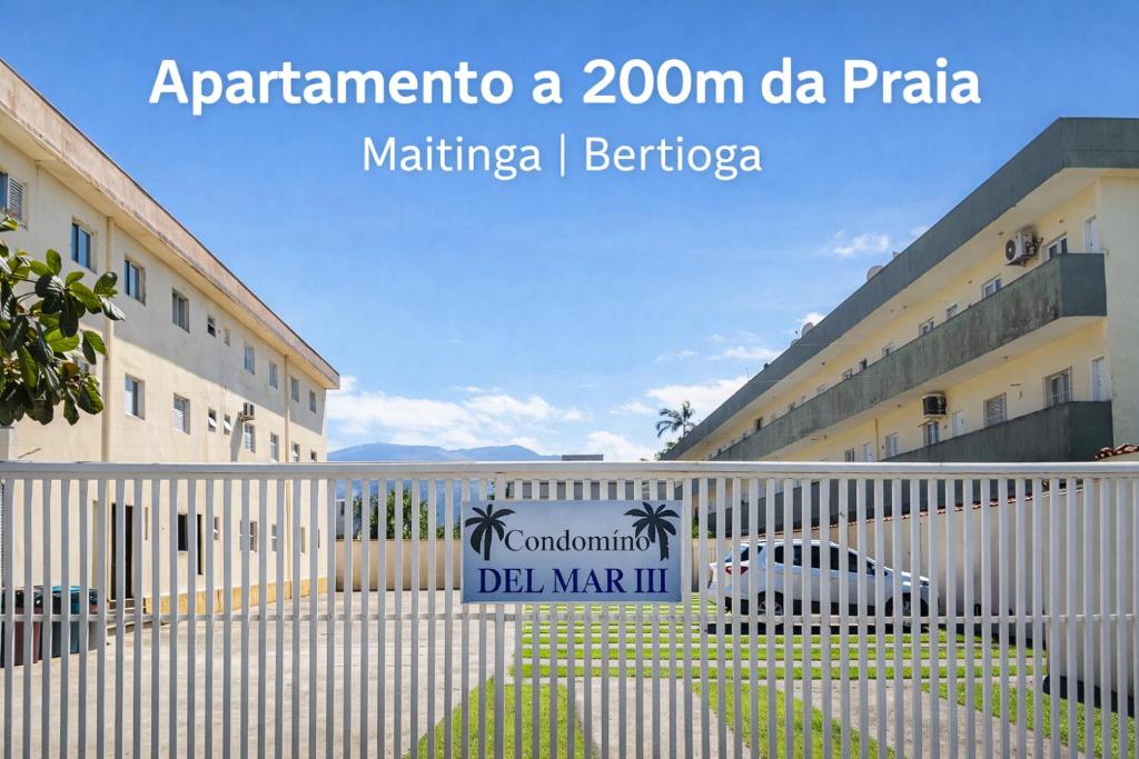 a sign on a fence in front of a building at Condomínio - Dell Mar III in Bertioga