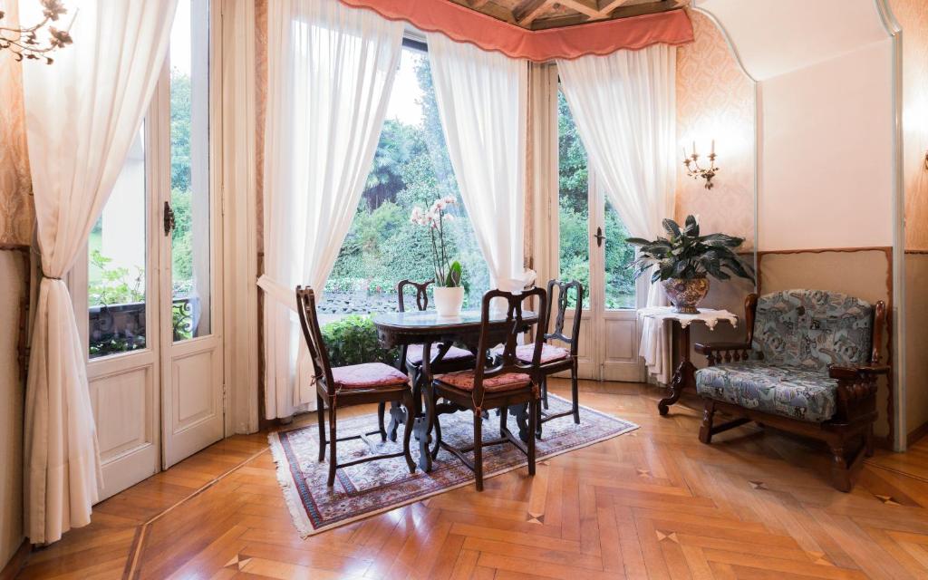 a dining room with a table and chairs and a window at Hotel Du Parc in Stresa