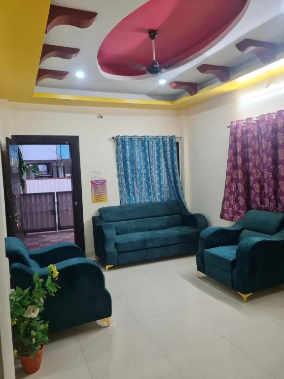 a waiting room with green couches and purple curtains at Umashankar Homestay in Nashik