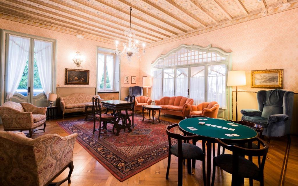 a living room with a table and chairs at Hotel Du Parc in Stresa