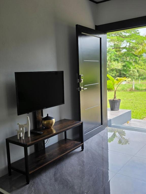 a living room with a tv and a table with a television at Casa del Lago #3 in Upala