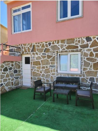 a building with two chairs and two benches in front of it at Casa Rosa da Serra in Sintra