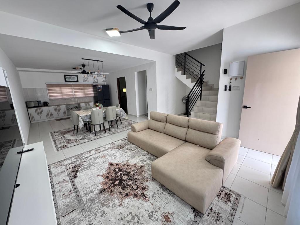 a living room with a couch and a ceiling fan at KY Stay D'Serkam in Serkam