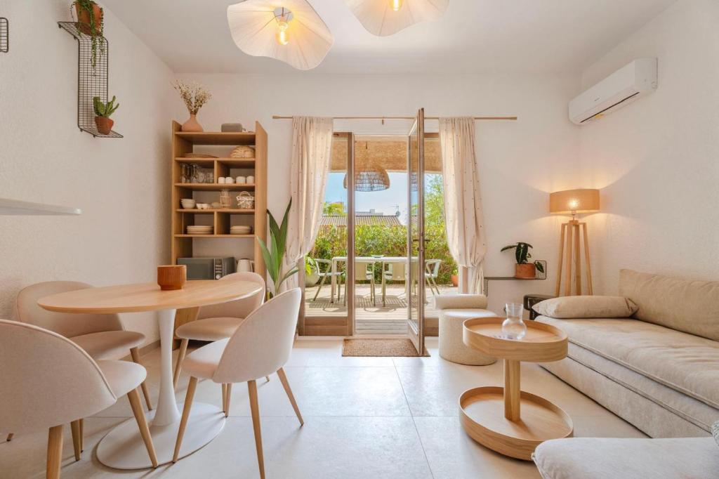 a living room with a couch and a table and chairs at T2 Haut de gamme avec jardin privé - 50m du port Miramar in La Londe-les-Maures