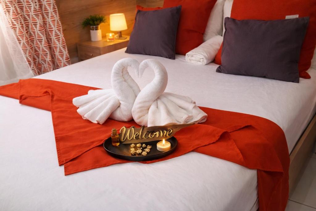 two towel swans sitting on top of a bed at Dreamy Oasis in Marigot