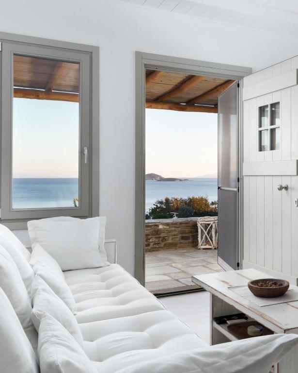 a living room with a white couch and a view of the ocean at West Side Garden House in Gavrio