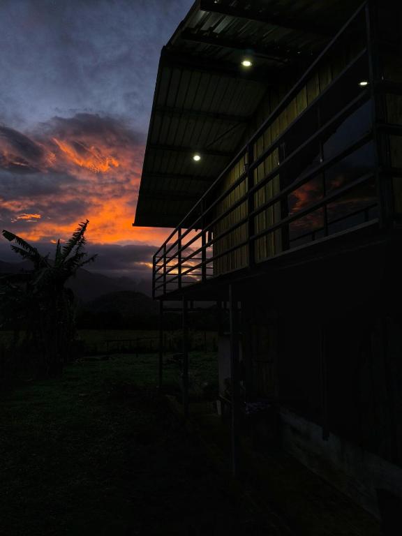 a building with a sunset in the background at Cabaña Cherenga in Sarchí