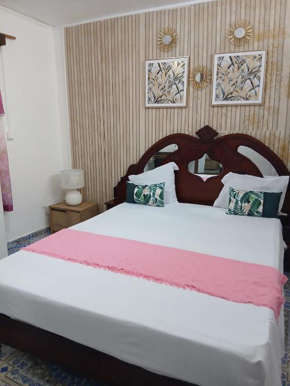a bedroom with a large bed with a wooden headboard at Les Jasmins partagées in Mamoudzou