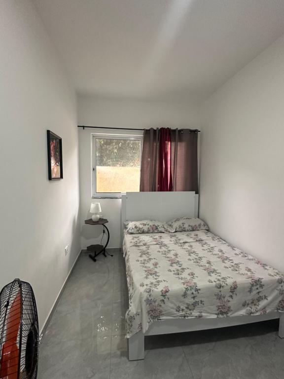 a bedroom with a bed and a window at Quarto- Espaço Casa Mendes in Praia