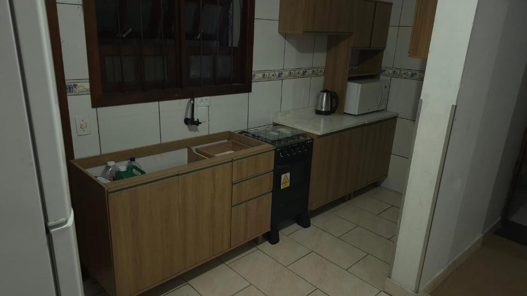 a small kitchen with a stove and a sink at Pousada Ventos Bons in Osório