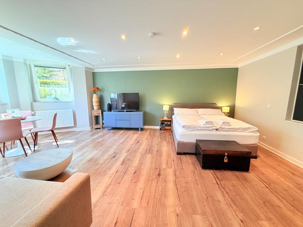 a bedroom with a bed and a table and a couch at Amaroo - Serviced Apartment "Andy" in Potsdam