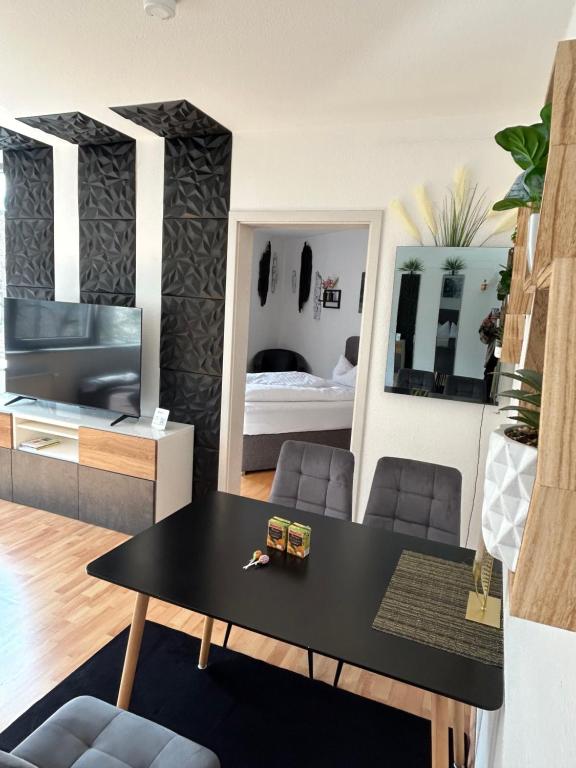 a living room with a table and a bedroom at Smartes Panorama City Apartment - Top Location! in Halle an der Saale