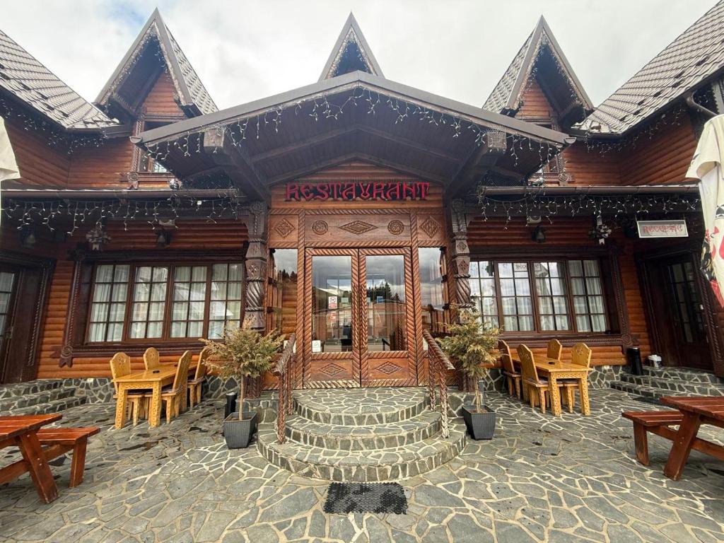 a building with tables and chairs in front of it at HANUL TENTEA in Săcel