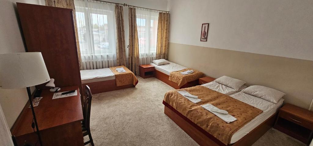 ein Hotelzimmer mit zwei Betten und einer Lampe in der Unterkunft Rest Hostel Airport Modlin in Nowy Dwór Mazowiecki